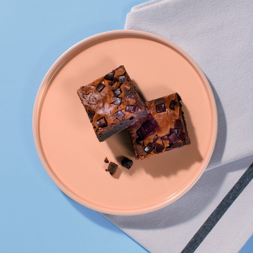 Close-up of Choc Chunk Brownie squares showing rich dark chocolate chunks.
