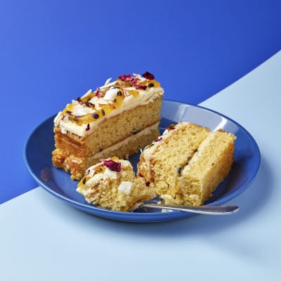 two slices of passionfruit coconut traycake served on a blue plate