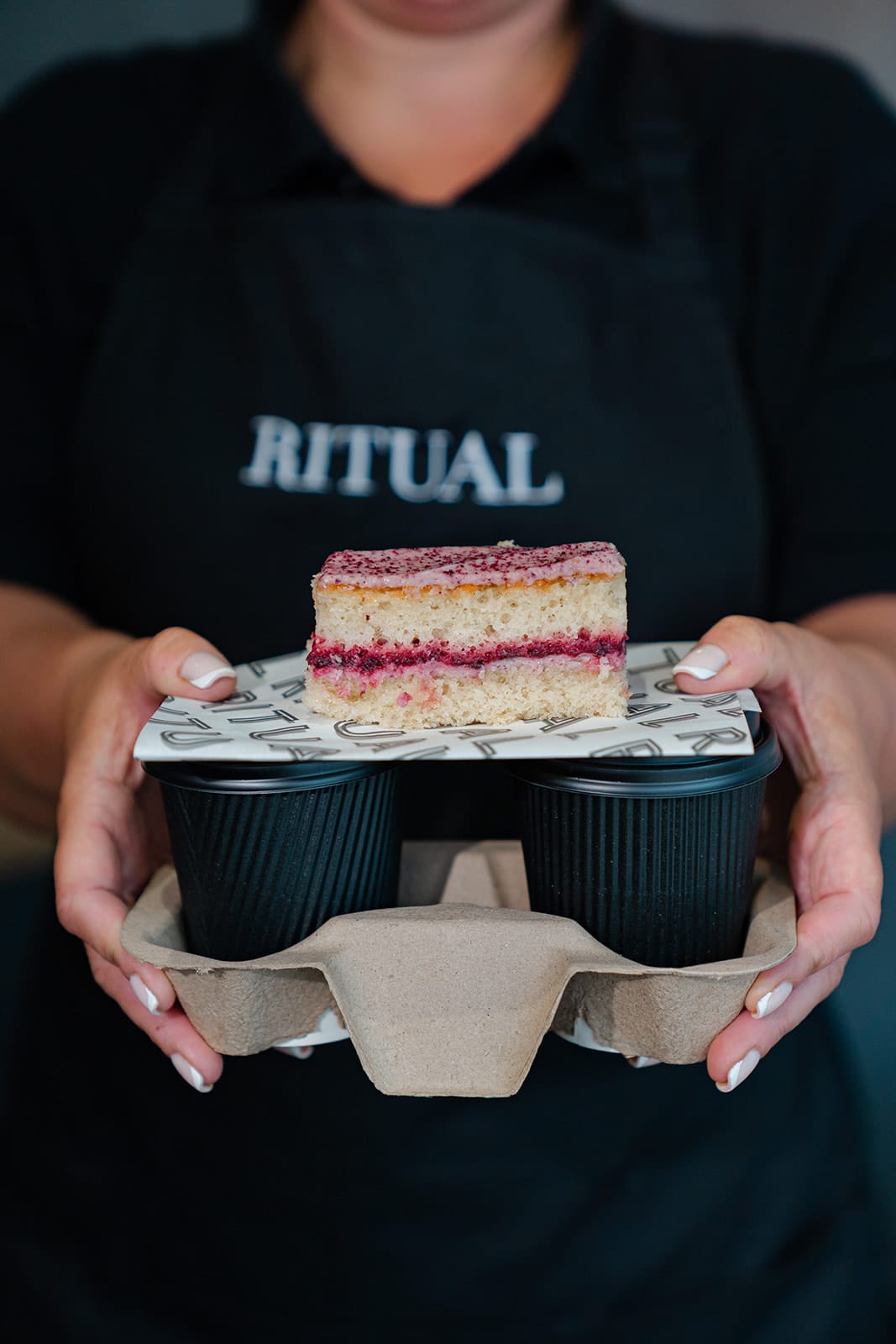Blackberry and Mascarpone Traycake on top of two take away coffee cups