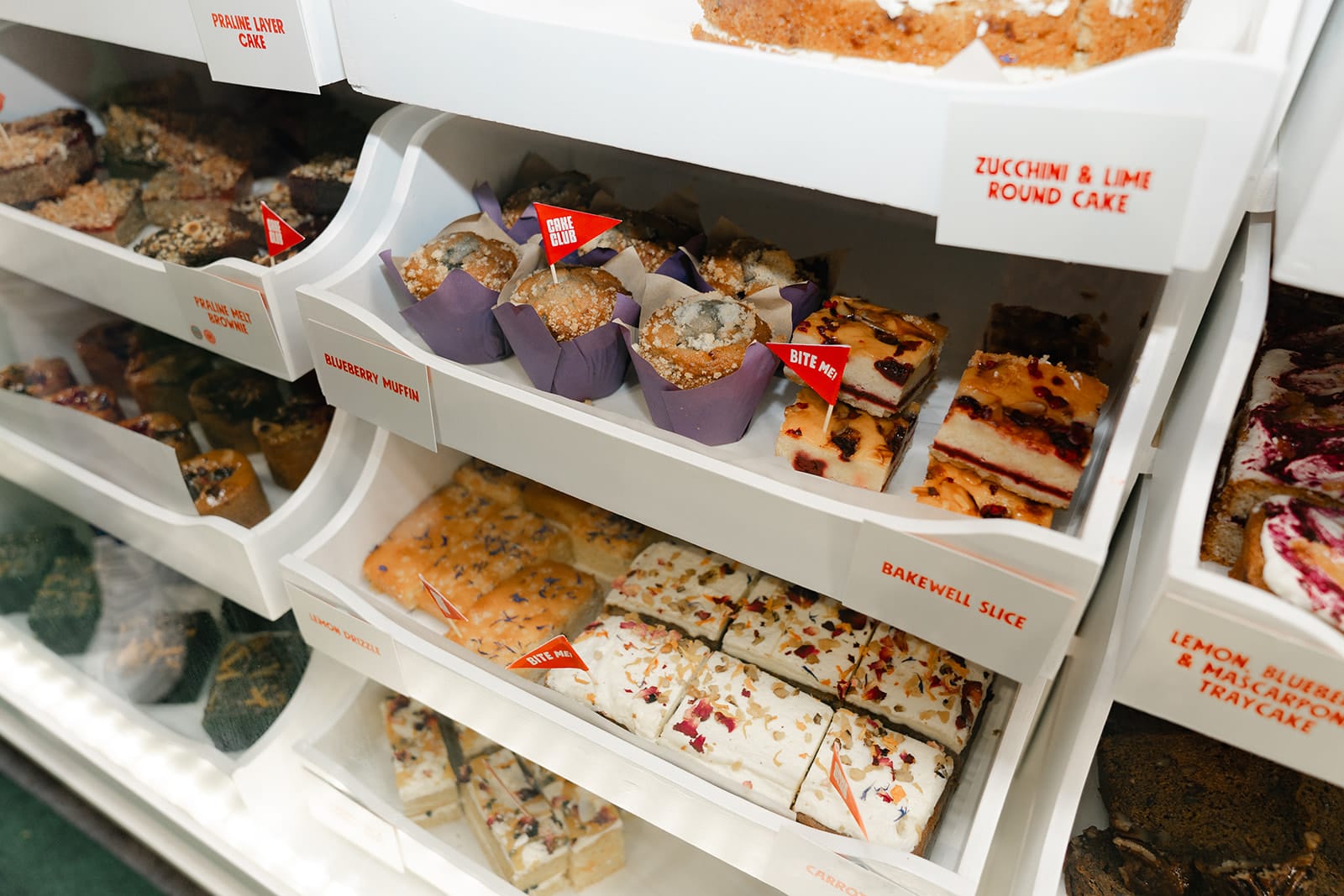 square cakes and round muffins on display for profitable cake offering post